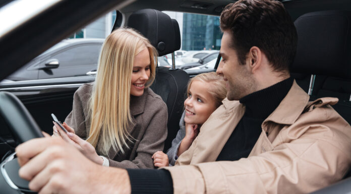 Road-Trip Ready: 6 Cabin-Comfort Upgrades That Make Long-Haul Driving Less Exhausting Family sitting inside a car and smiling together during a drive, representing a quieter and more comfortable cabin experience with automotive sound deadening materia